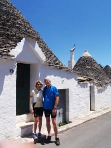 A couple stands outside the door of a Puglia trullo